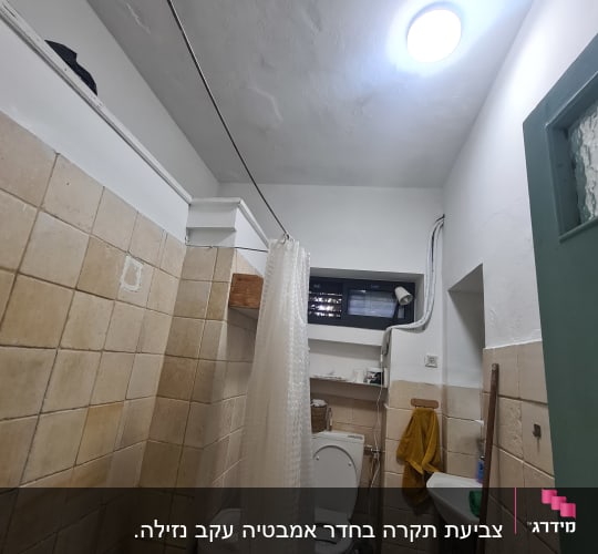 חדר אמבטיה עם אריחים ותקרה צבועה